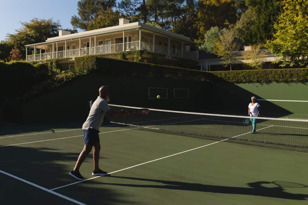 Sport Court Concept: Couple playing on Tennis court in their backyard